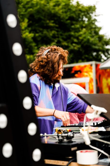 DJ bei einer Veranstaltung, während er an einem Plattenspieler arbeitet.