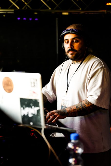 DJ mit Kopfhörern am Mischpult, konzentriert auf die Musik.