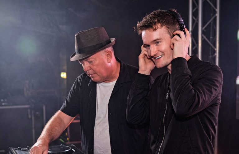 Roubix Zwei DJs stehen an einem Mischpult und hören aufmerksam Musik.